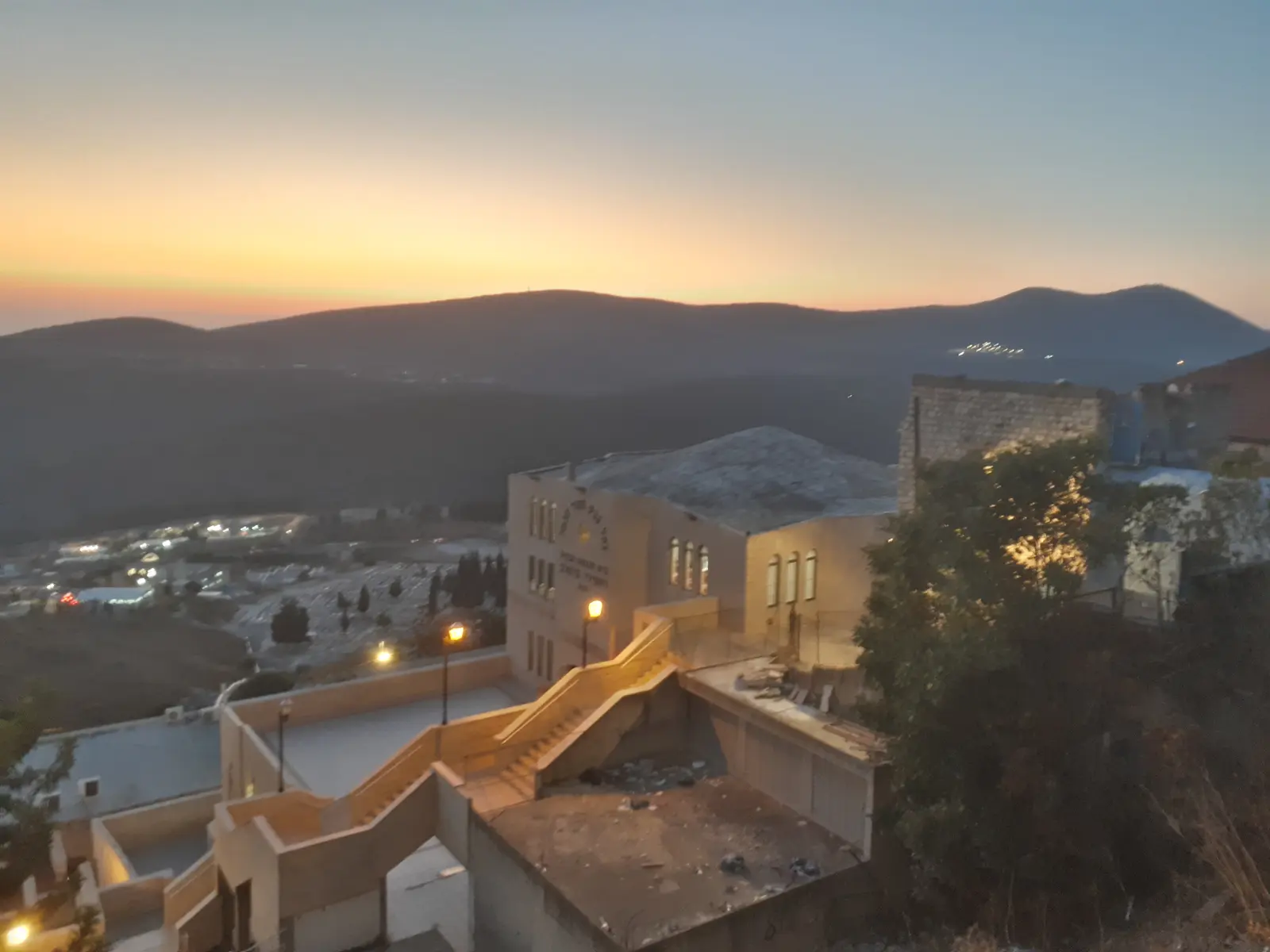 Sunset over the rooftops and old stairways of Tzfat, with the Galilee hills behind